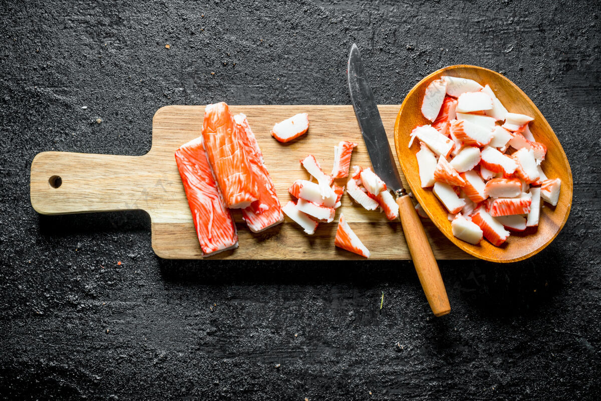 食物螃蟹片用刀粘在木头砧板上准备营养海鲜