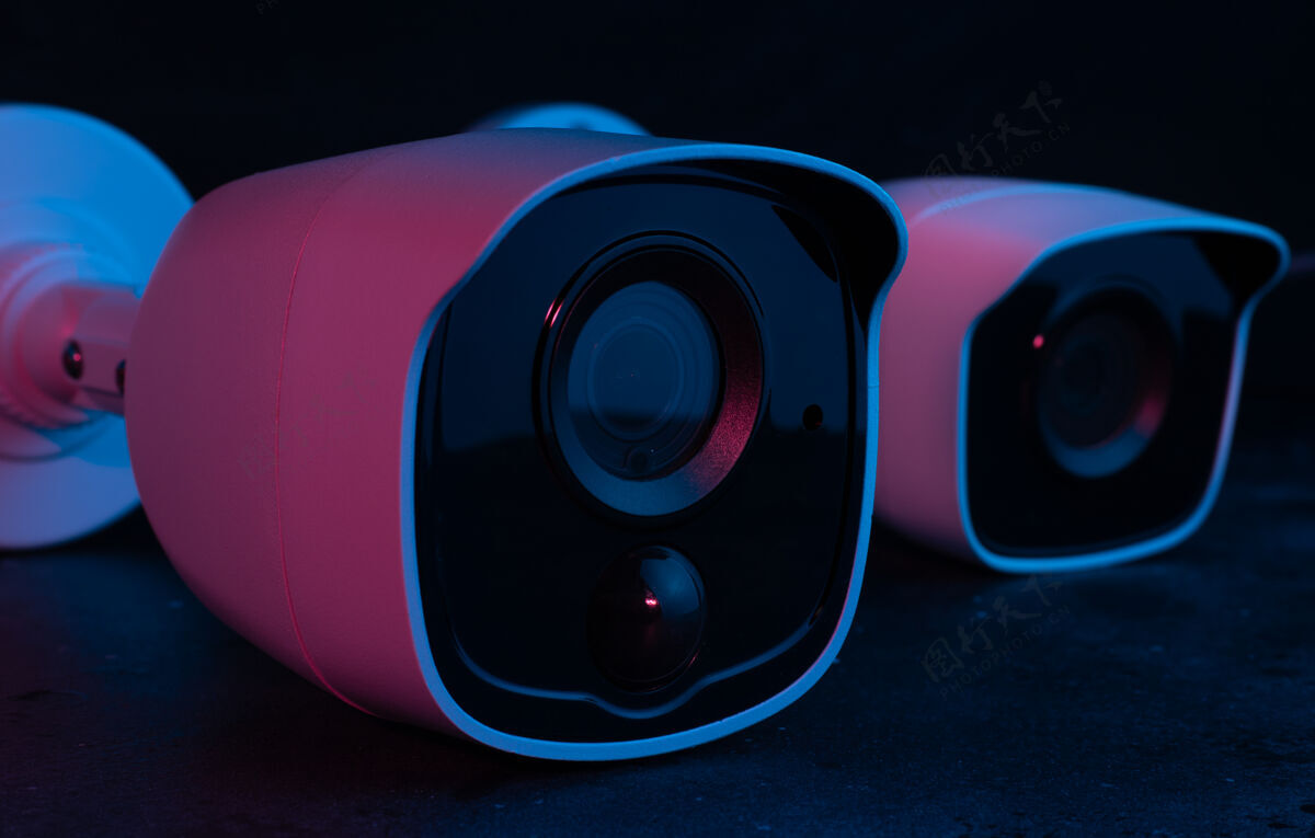 安全在粉色灯光下 在黑暗的表面上的摄像头安全技术监视隐私