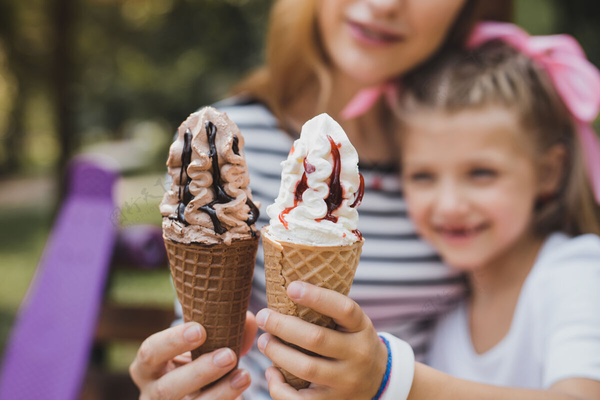 女儿巧克力和香草妈妈和女儿在吃美味可口的巧克力和香草冰淇淋休息情绪香草