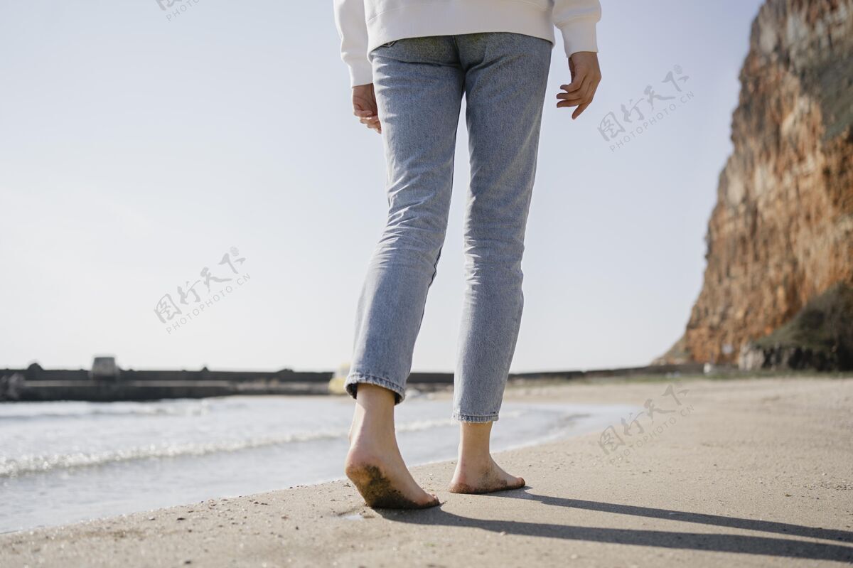 年轻走在沙滩上的年轻女子流浪自由旅行