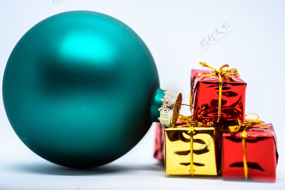 新年特写镜头的绿色圣诞树装饰附近的彩色礼物圣诞节四季闪亮