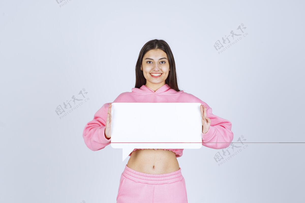 女人穿着睡衣的女孩手里拿着一张空白的长方形纸条 看上去既惊讶又高兴积极模特工人