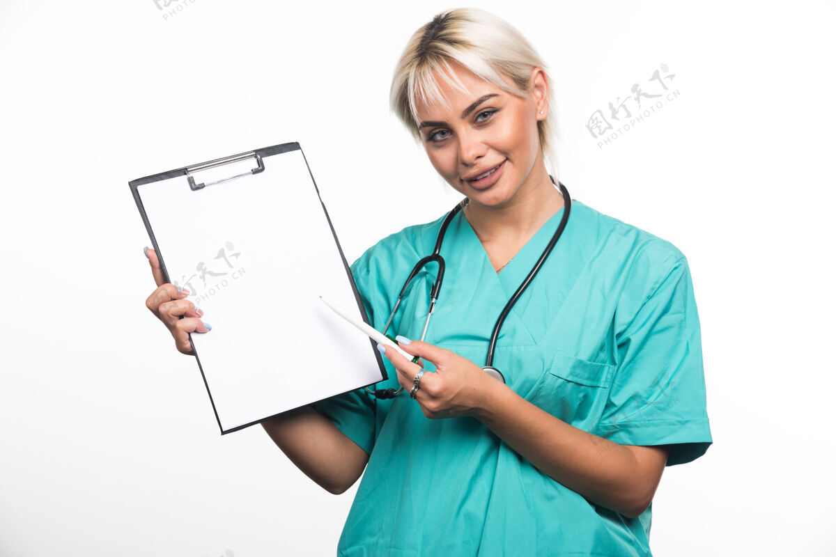 工作面带微笑的女医生用白纸笔指着剪贴板制服女性成人