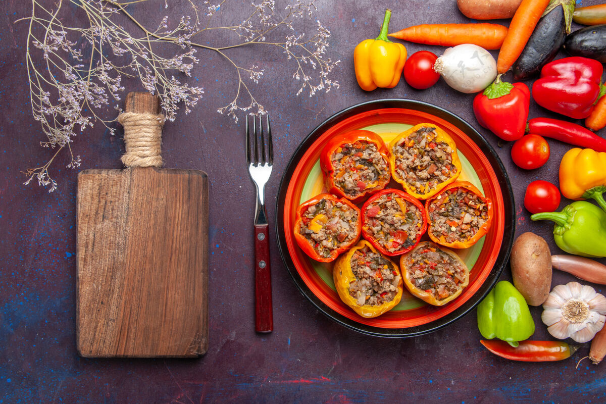 甜椒顶视图熟甜椒与蔬菜和不同的调味品对深灰色的表面食物多尔玛蔬菜餐牛肉顶部生的餐厅