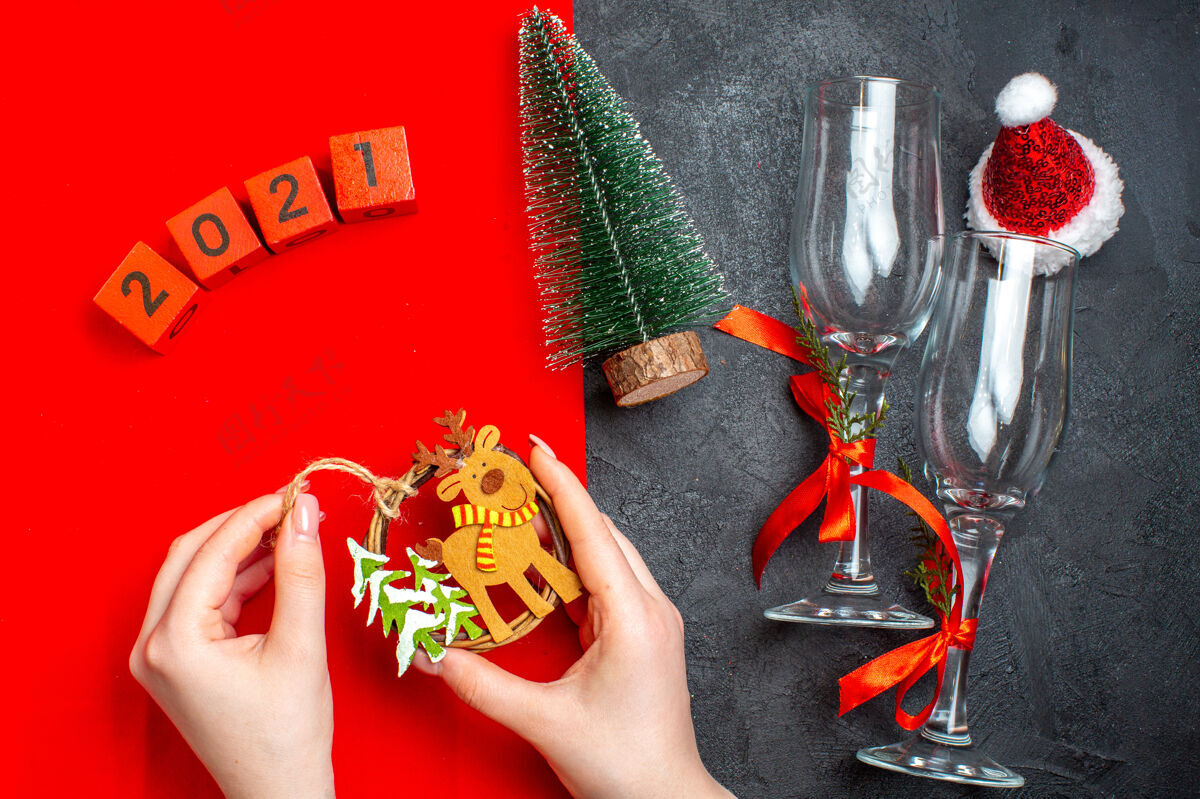玻璃高脚杯手持式装饰配件玻璃高脚杯顶视图圣诞树数字红色和黑色背景上的圣诞老人帽子视图瓶子数字