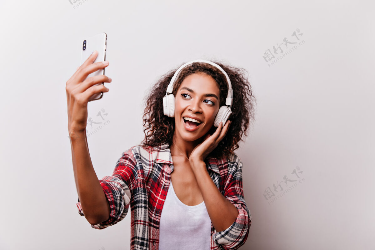 现代优雅的黑人女孩一边听音乐一边拍照热情的女人一边用手机自拍女性非洲笑