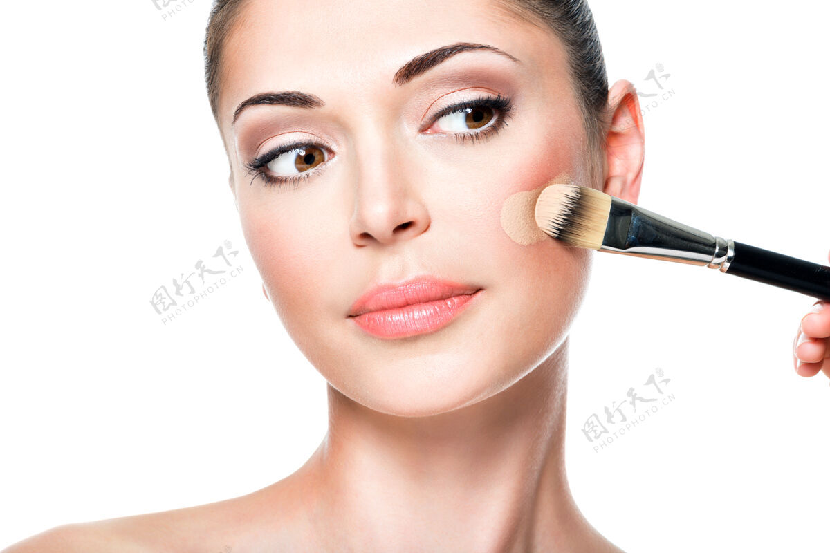 化妆品化妆师在女人脸上涂上液体色调的粉底治疗模特魅力