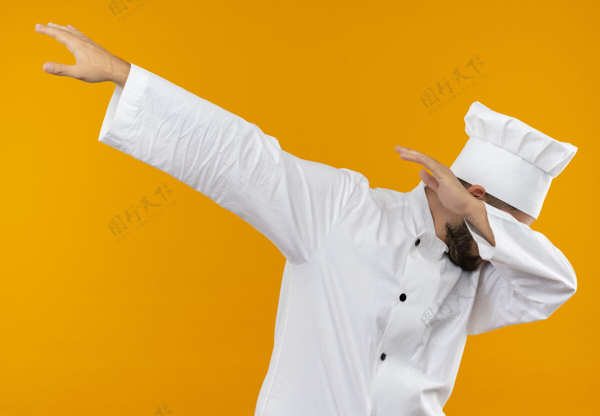 动作身着厨师制服的年轻男厨师在橙色的空间里做着与世隔绝的手势厨师厨师橙色