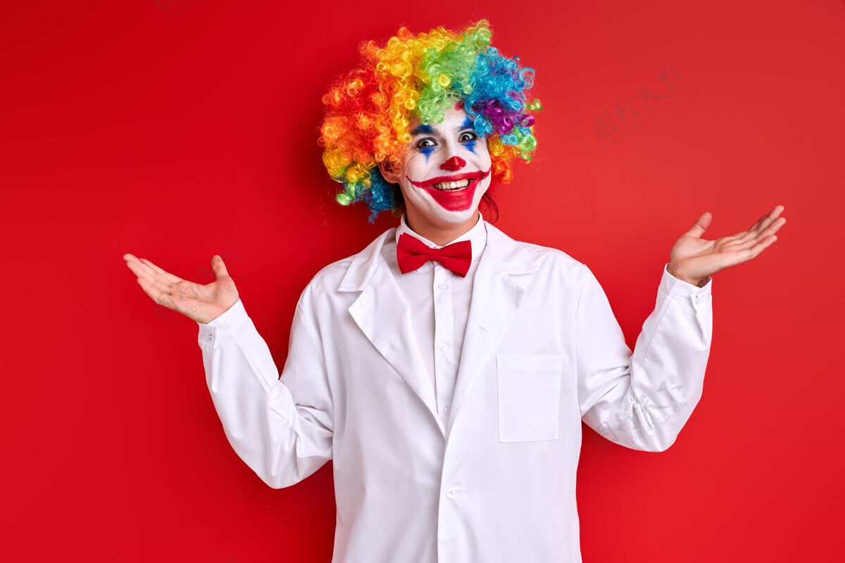 幽默丑角表演 小丑面带笑容 身穿白色服装 在红色背景上画脸举行手枪服装