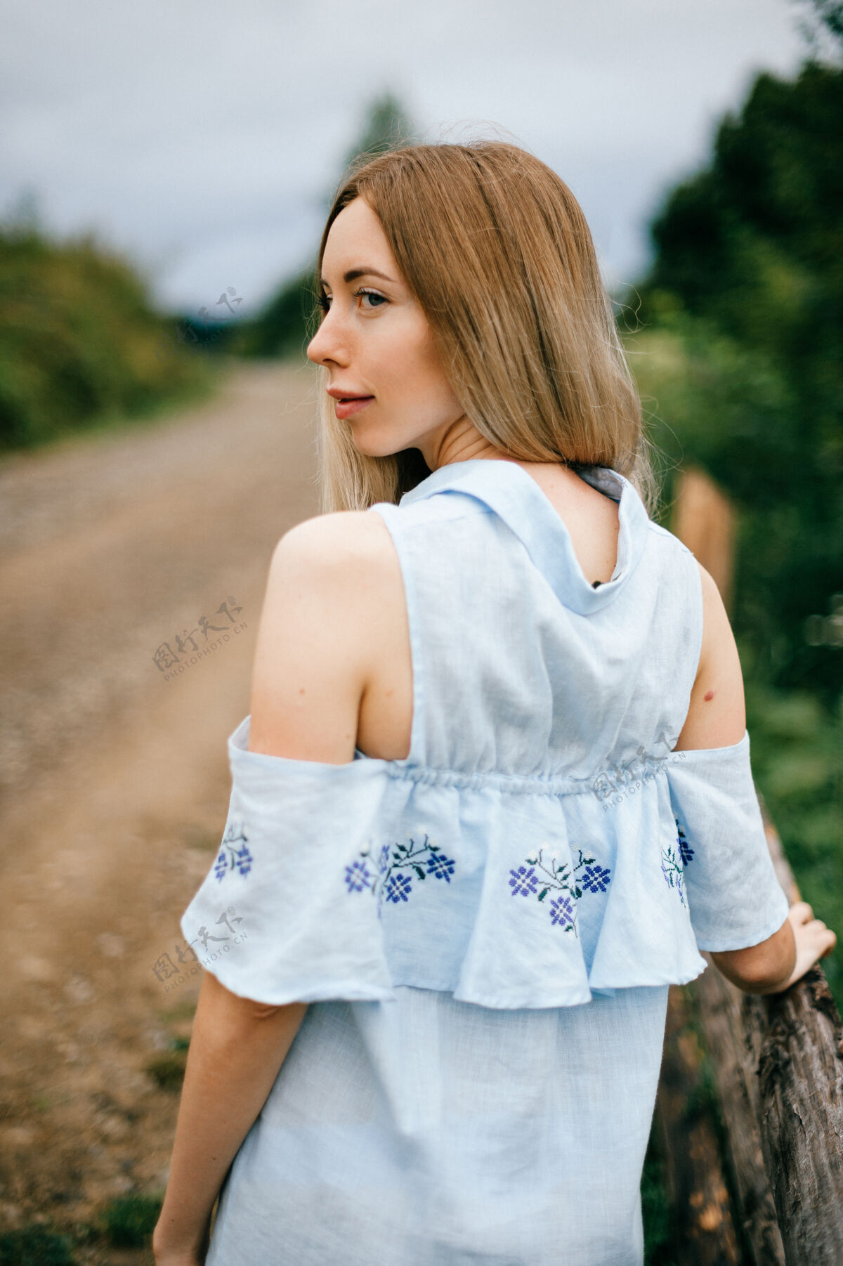 金发年轻迷人优雅的金发碧眼女孩 穿着蓝色连衣裙 在乡间摆姿势姿势女人乡村