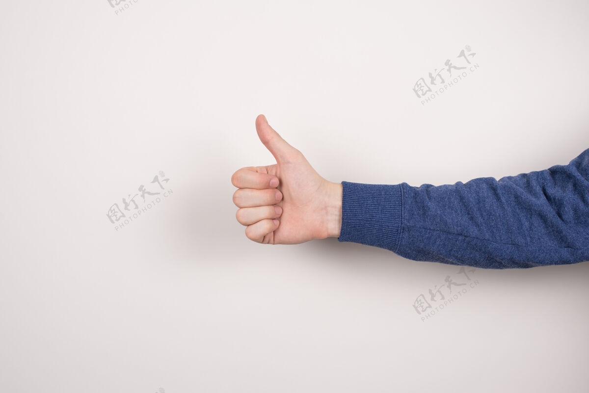 广告剪短特写照片的自信英俊聪明的商人自由职业者作出给予拇指孤立的灰色墙男人手势反馈