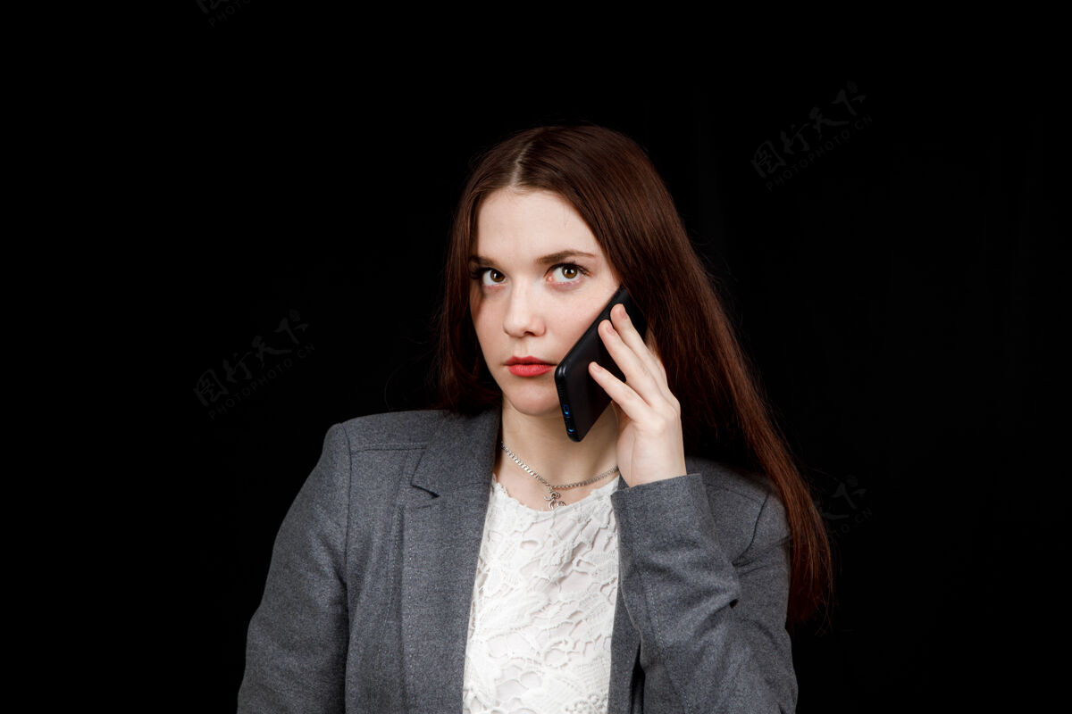 沟通快乐而成功的年轻时尚博主在电话里动情地交谈穿着休闲灰色夹克的漂亮年轻女子手里拿着智能手机女孩人无忧无虑