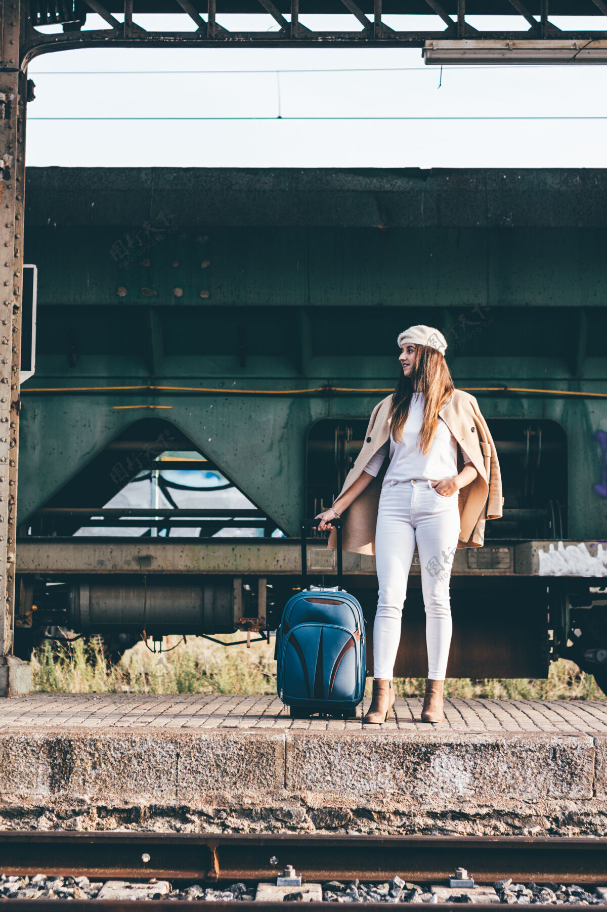 货车一个穿着贝雷帽和米色夹克的女人在一个旧火车站等火车女性城市铁路