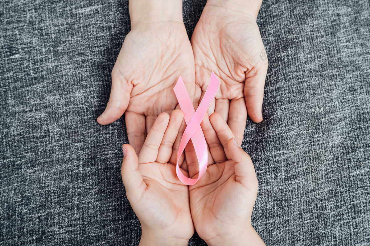 预防女儿和母亲的手上都有粉红色的癌症彩带意识丝带女孩