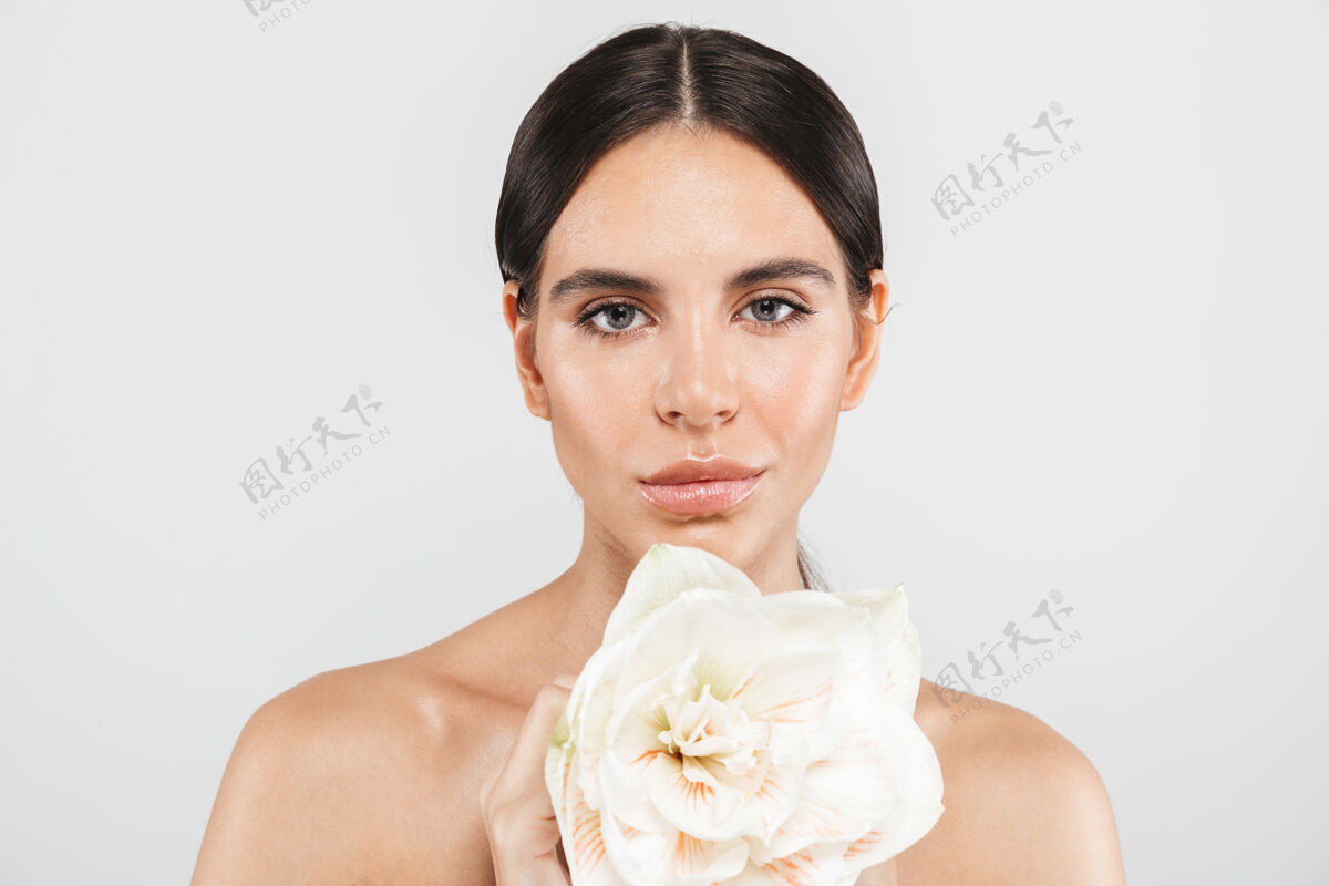 赤裸上身美丽的肖像一个迷人的感官健康的女人站在隔离的白色墙壁 摆出一朵花快乐成人新鲜