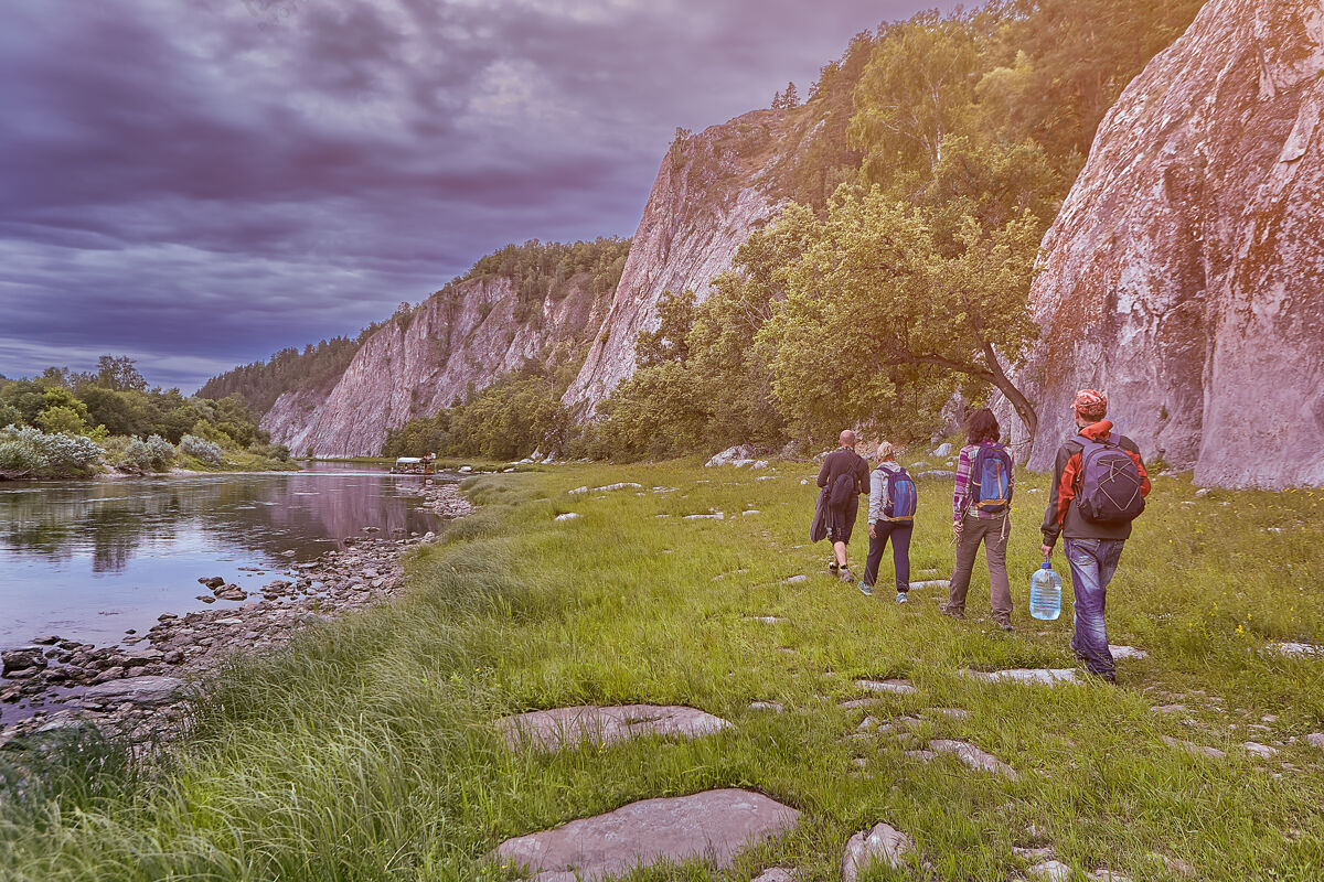 森林生态旅游 组团远足者走在沿河的小路上 在荒芜的岩石地带乡村环境多云