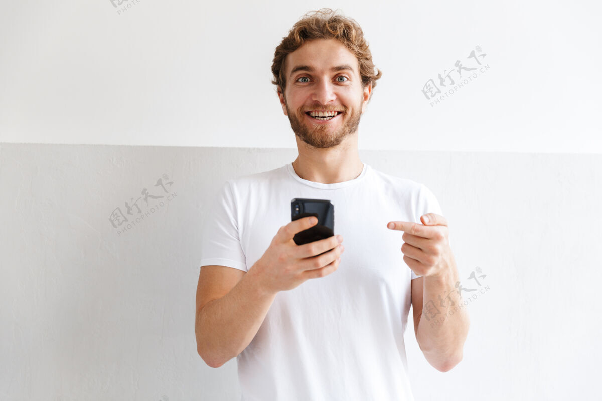 电话一个英俊的年轻人在家里使用手机的照片帅气年轻男人