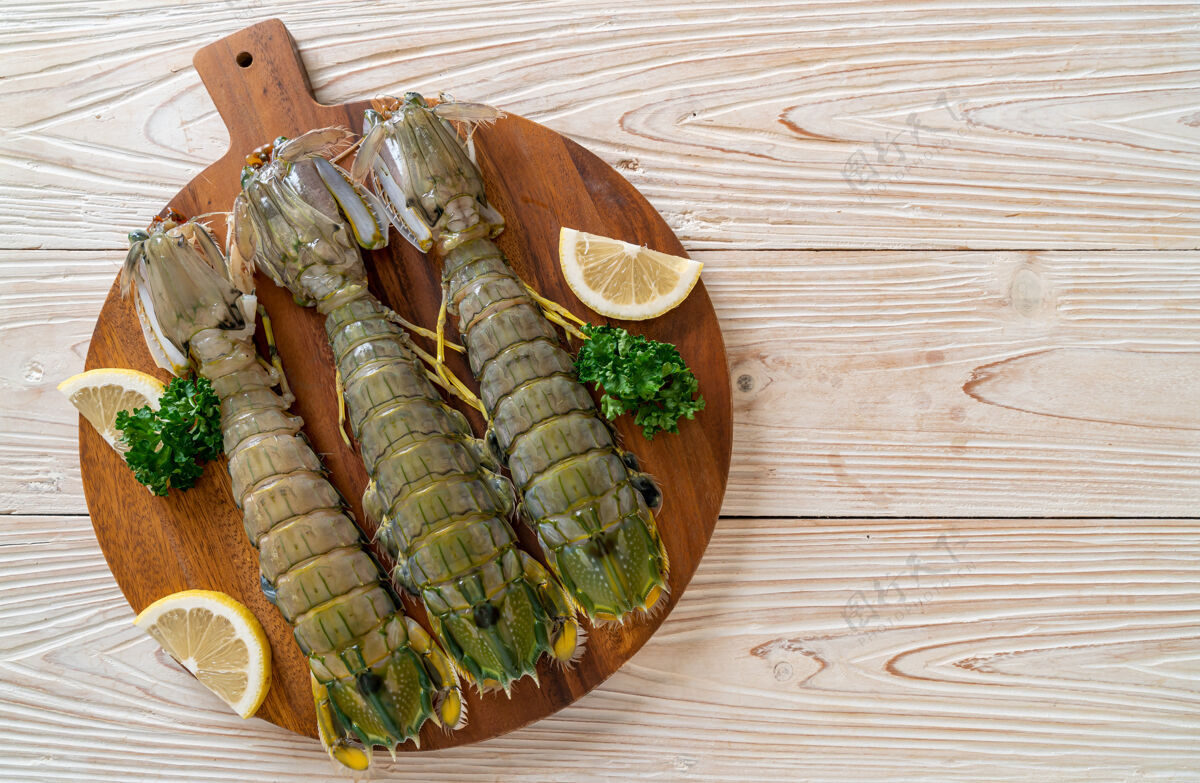 贝壳新鲜的柠檬螳螂虾在木板上销售餐厅虾
