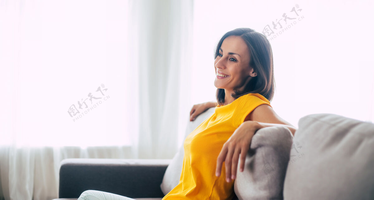放松美丽 冷静 自信的棕发女人假期在家里的沙发上休息和平休息房间