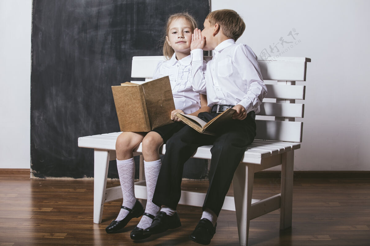 板岩快乐的男孩和女孩从小学班的板凳上看书的背景板兄弟学生小学