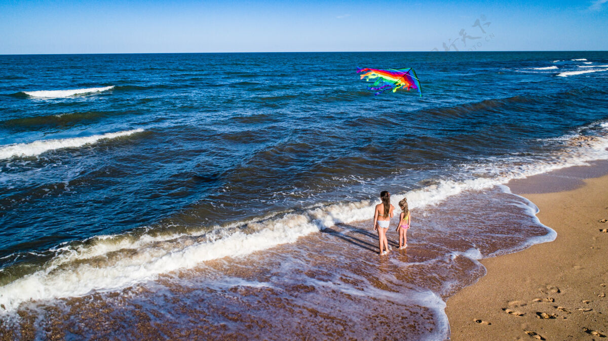 沙滩两个女孩在海边玩风筝海浪慢跑沙滩