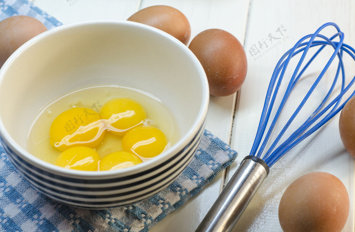 奶酪生鸡蛋和花冠在白色的表面蛋黄搅拌蛋壳