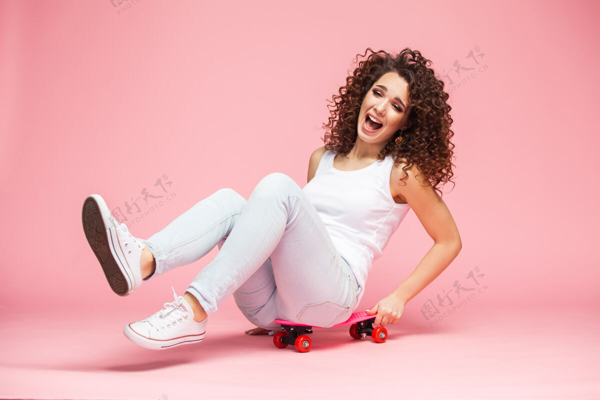 青少年快乐的年轻女子坐在滑板上 玩得很开心长度可爱的女孩爱