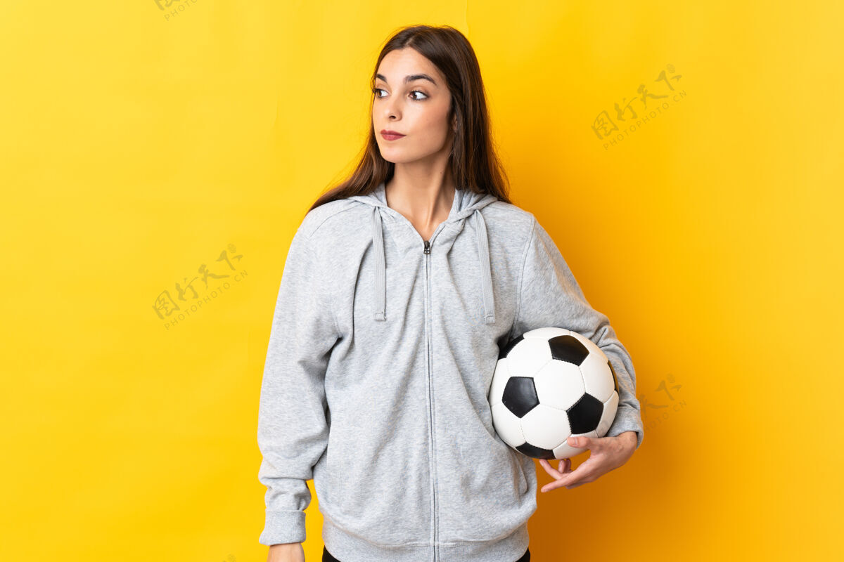 比赛一个年轻的足球运动员 一个穿黄色衣服的女人 朝旁边看成人职业肖像