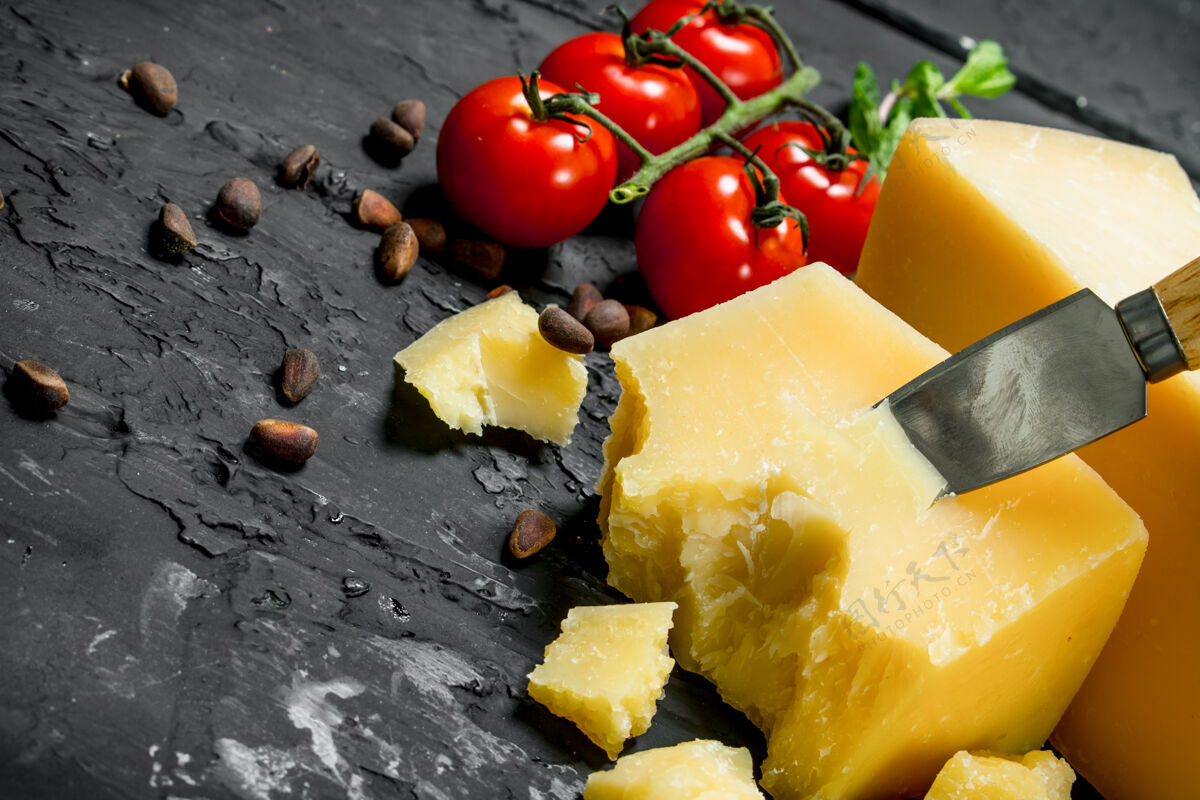 地中海帕尔马干酪配西红柿 松子和薄荷叶放在黑色的乡村餐桌上薄荷奶酪橄榄