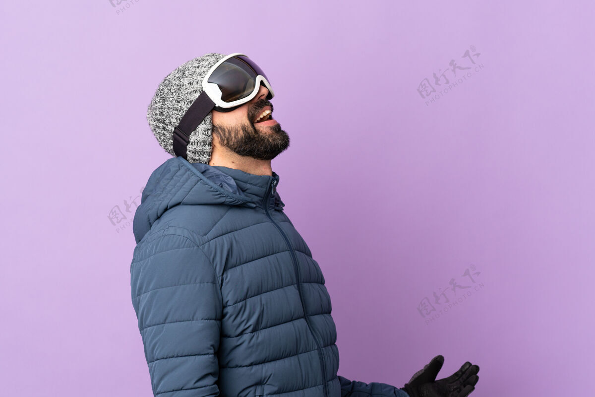 人带着滑雪眼镜的滑雪者越过隔离的紫色墙壁冬天肖像成人