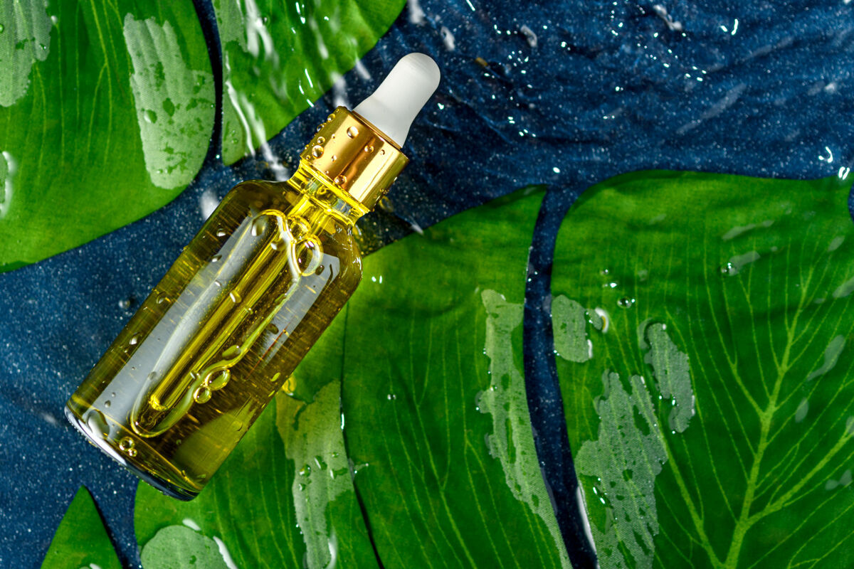 精华玻璃瓶 带吸液管和化妆品黄浆 绿叶和水 护肤理念有机产品油