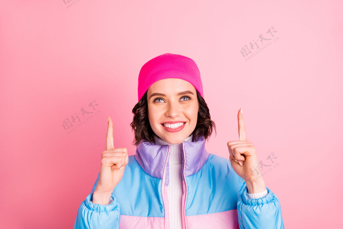 Recommendation好女人的照片表明举手空位穿暖色外套隔离粉红色背景GirlFemalSmile