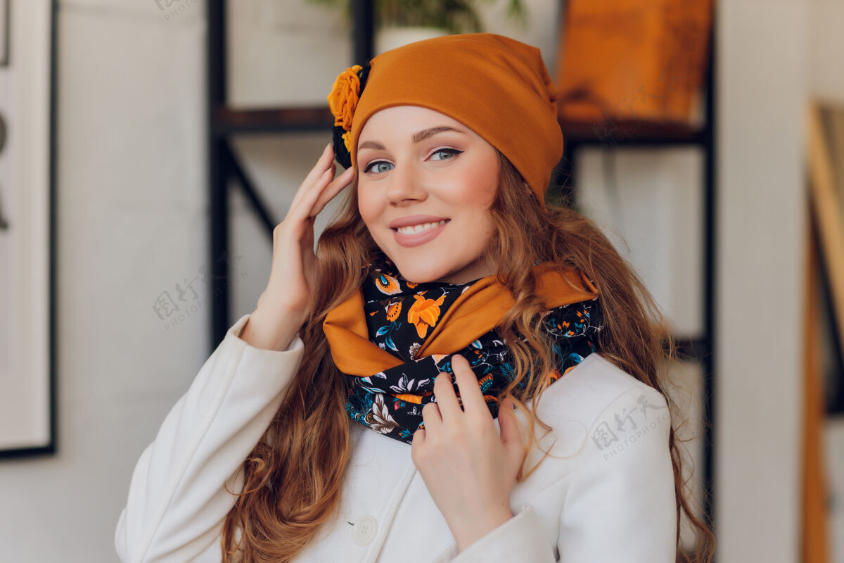 舒适快乐美丽的女人侧身看着兴奋女孩戴着暖和的针织帽子和手套温暖自然新