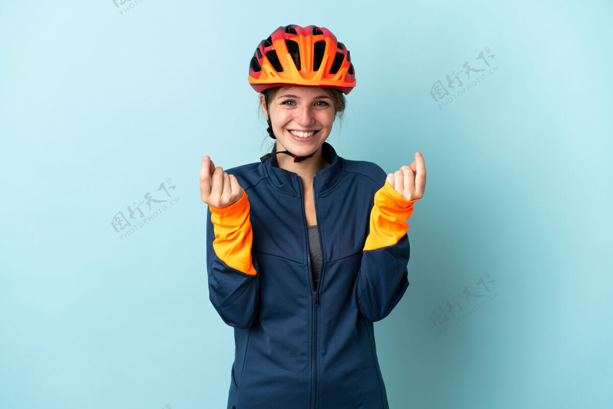 经济年轻的骑自行车的女人孤立的蓝色背景赚钱的姿态骑自行车女性富有
