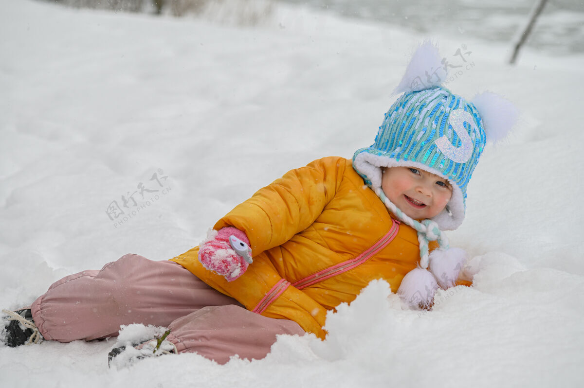 小可爱的小女孩在雪地里玩雪宝宝年轻