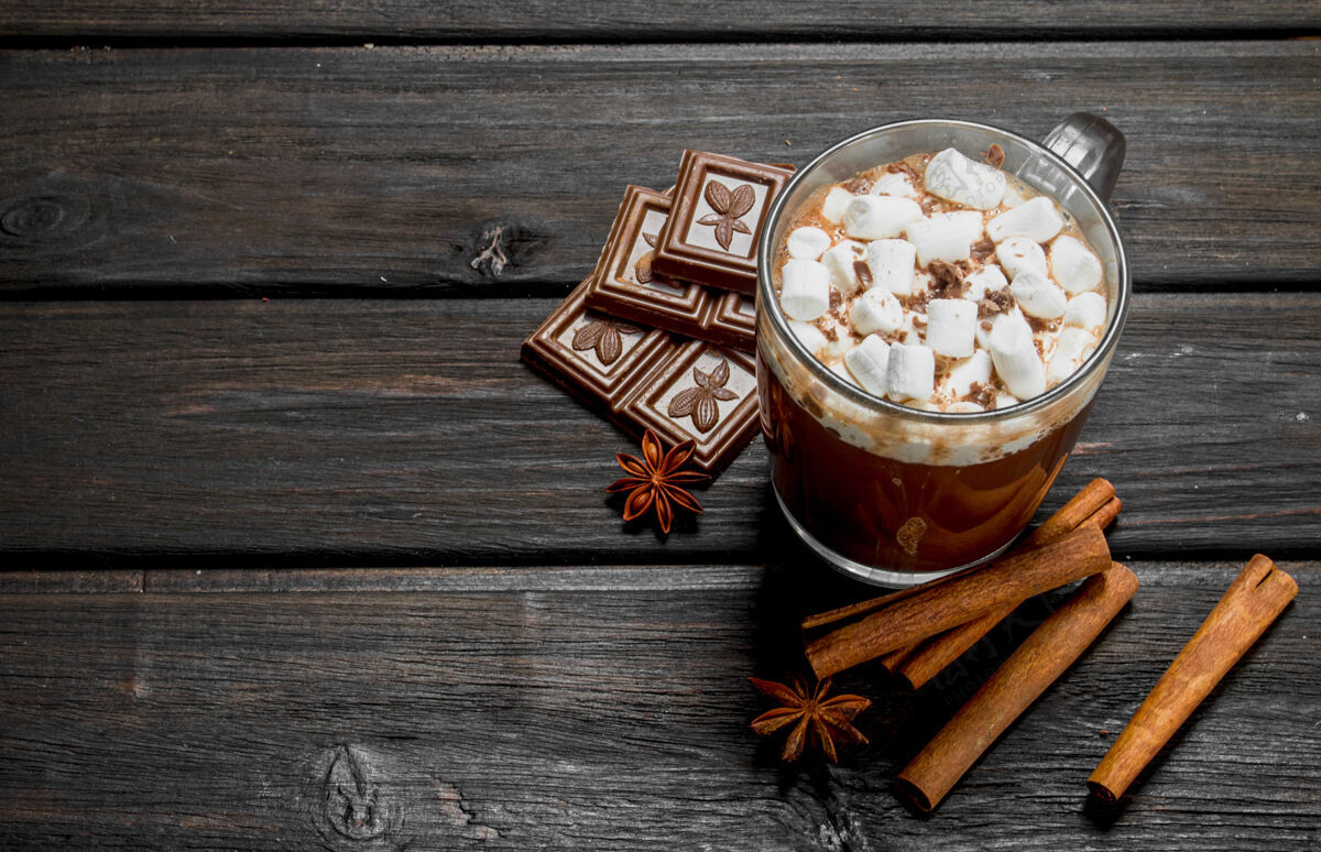美味热巧克力加肉桂和棉花糖放在木桌上棕色液体温暖