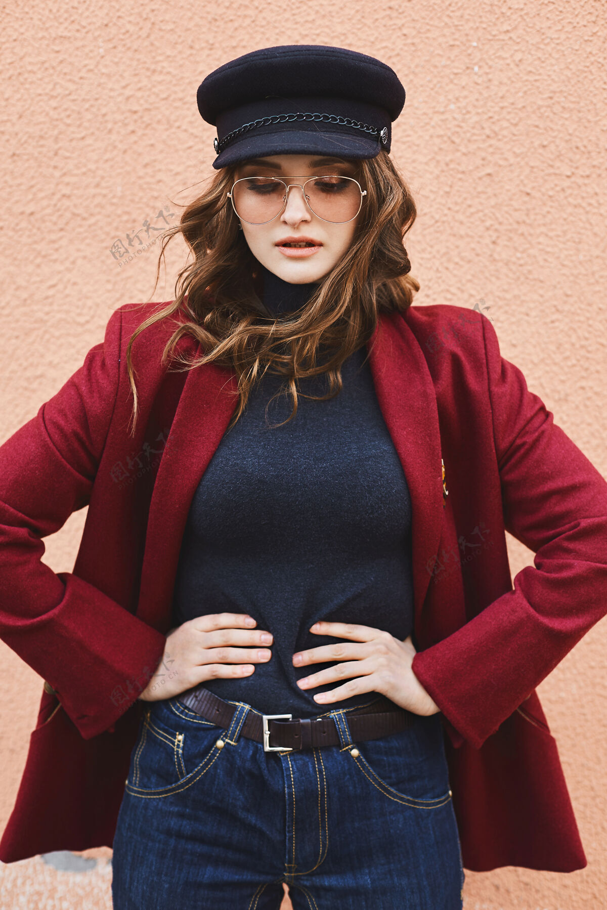 春天年轻的模特儿戴着时髦的太阳镜 穿着红色外套 戴着时髦的帽子在户外摆姿势时尚漂亮外面