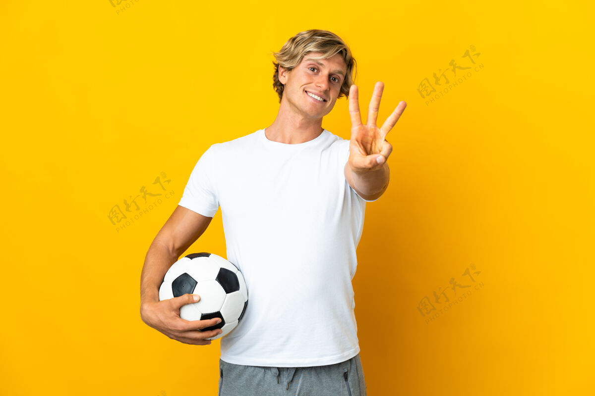 三英国足球运动员在孤立的黄色背景下快乐地用手指数着三个澳大利亚数字训练