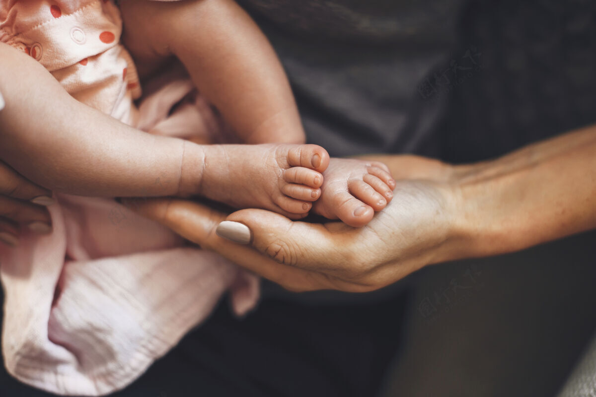 手臂高加索人的父母抱着他刚出生的女儿在睡觉时的脚母性节日婴儿
