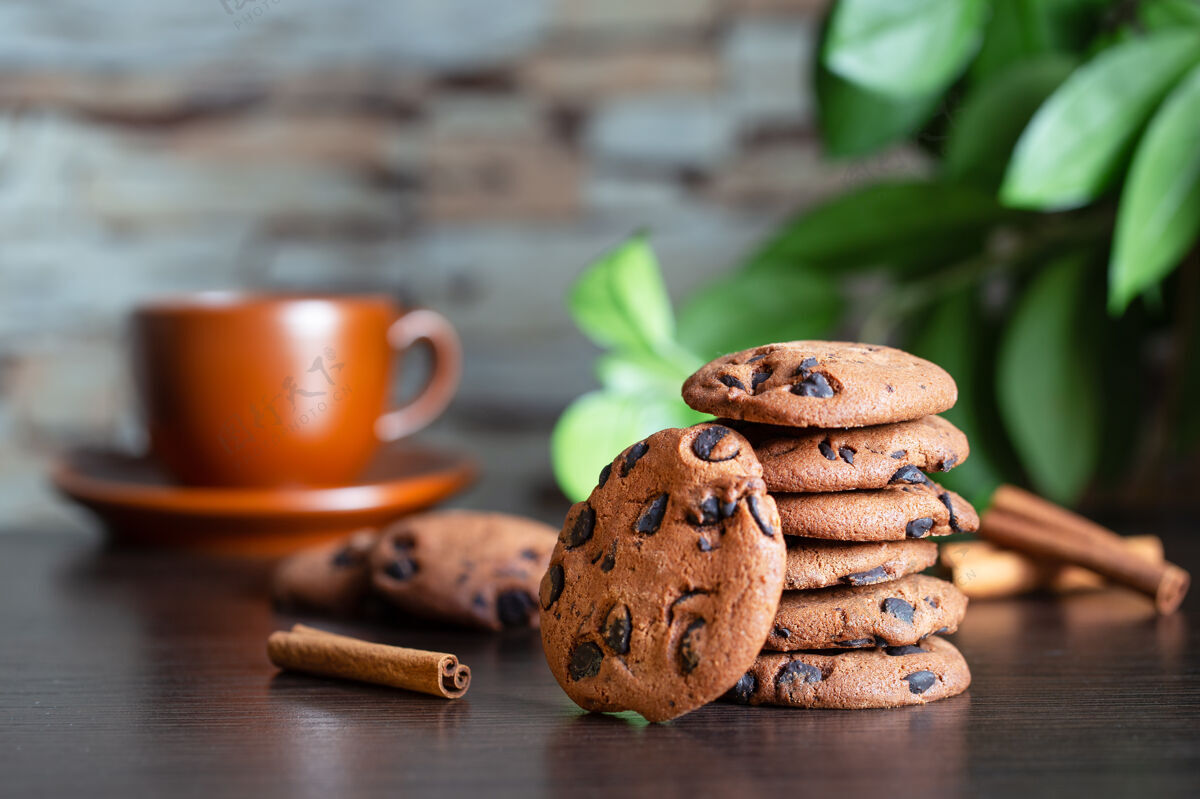 木头在一杯咖啡和绿色的背景下 桌上放着巧克力燕麦片饼干树叶早餐或者早上喝咖啡堆栈饮食薯片