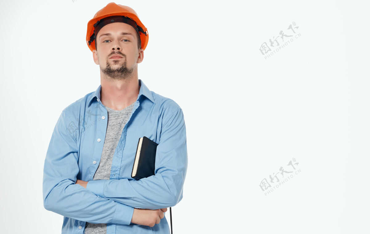 工作男性建筑师戴着橙色安全帽 工作着灰色裁剪的风景建筑手安全