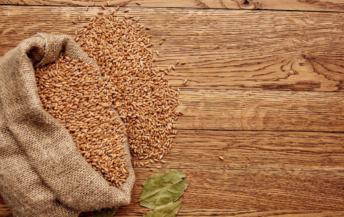 整个小麦在一个袋子里放在一张木桌上 干叶有机质感墙上的形象稻草特写收获