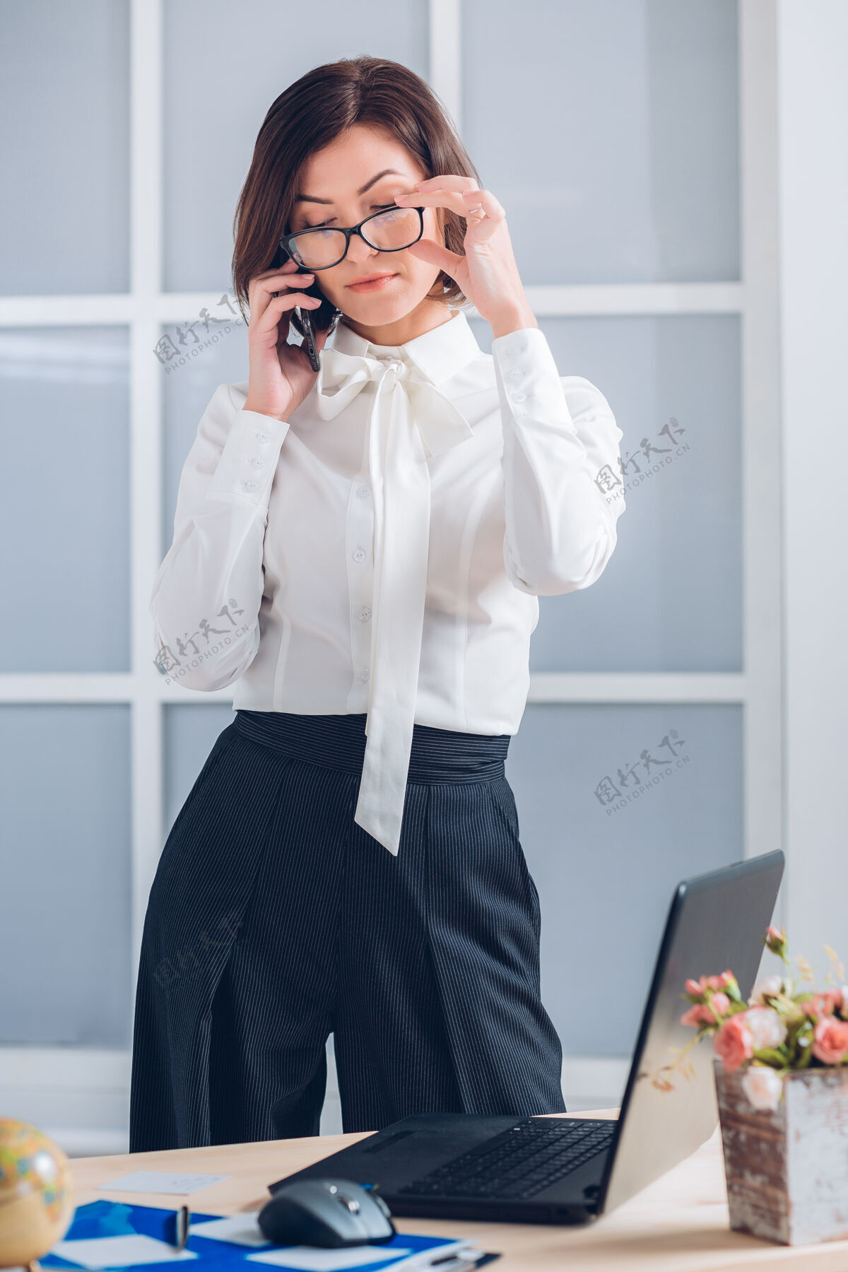 优雅的商务女士在办公室打电话计算机快乐笔记本电脑