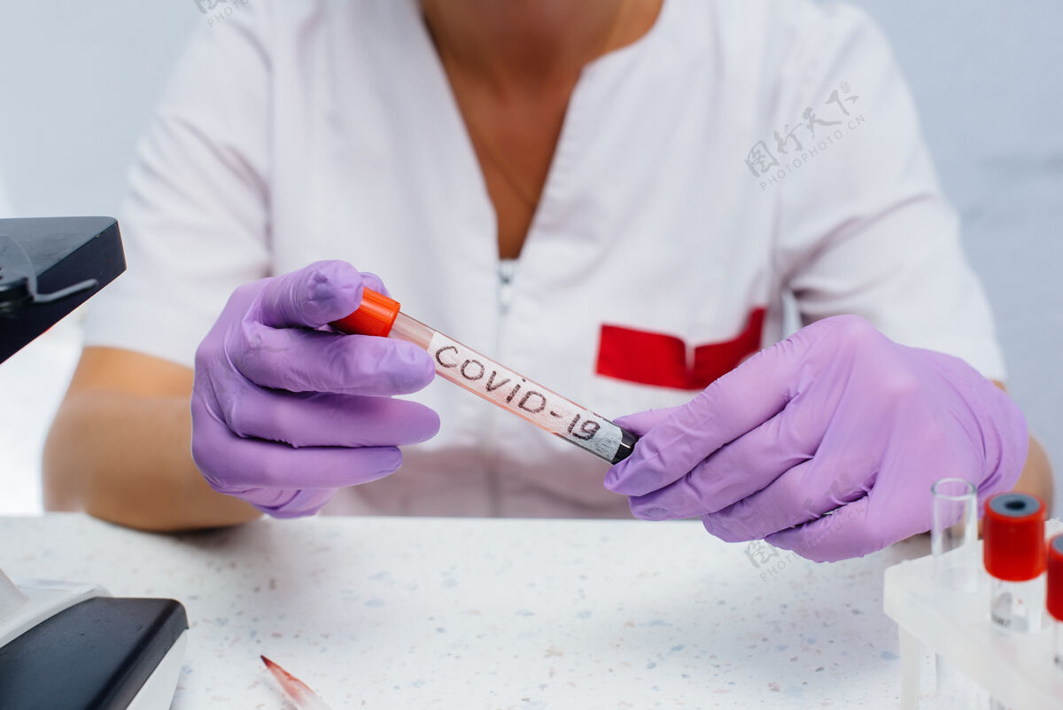 手实验室里的一位女医生拿着一个对covid-19呈阳性的试管危险病毒和细菌的研究流行病诊断医院