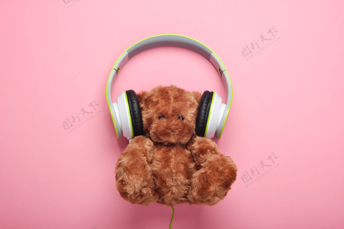 音乐泰迪熊与立体声耳机粉红色粉彩表面孩子有声读物泰迪