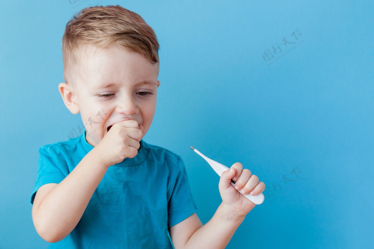 测量一个生病的小孩拿着一个吸热剂 量着他发烧的高度 看着镜头肖像温度手