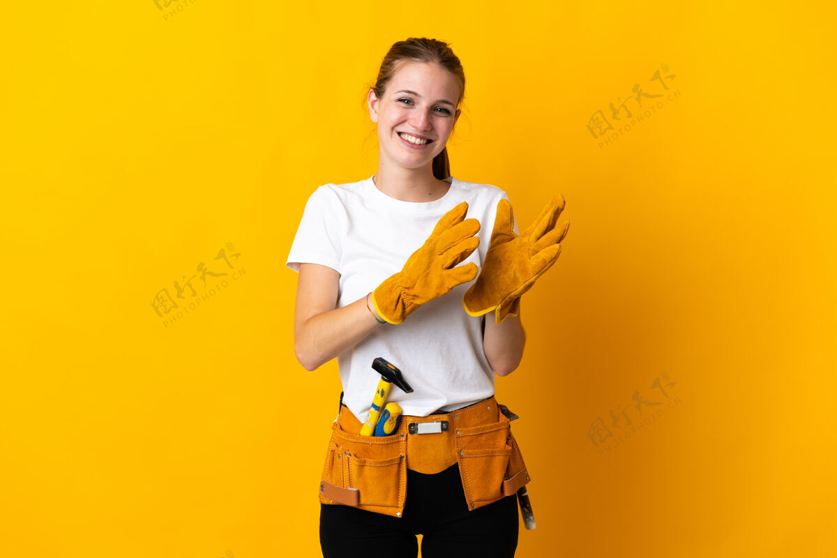 大笑一位年轻的电工女士在会议上发言后 被隔离在黄色背景下鼓掌职业鼓掌欣赏