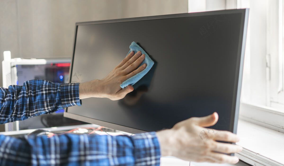 显示器一只手拿着一块抹布 擦拭着一个数码监控屏幕的装置工作家务房间