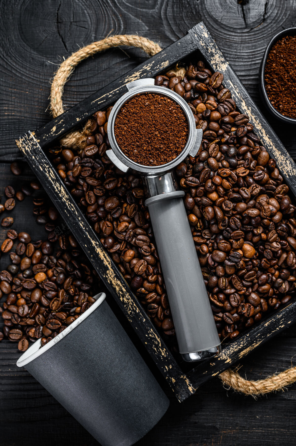 新鲜的咖啡豆木制托盘中的浓缩咖啡滤器桌面查看堆磨碎的咖啡豆