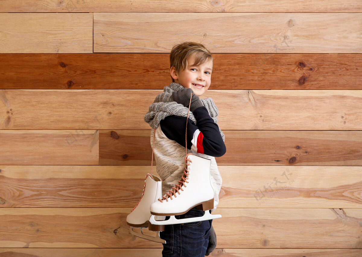 休闲可爱的小男孩用冰鞋抵着木头木头可爱温暖